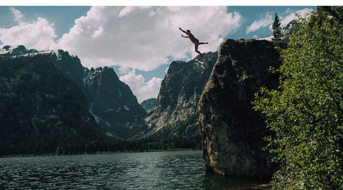 background image of a person jumping into a lake
